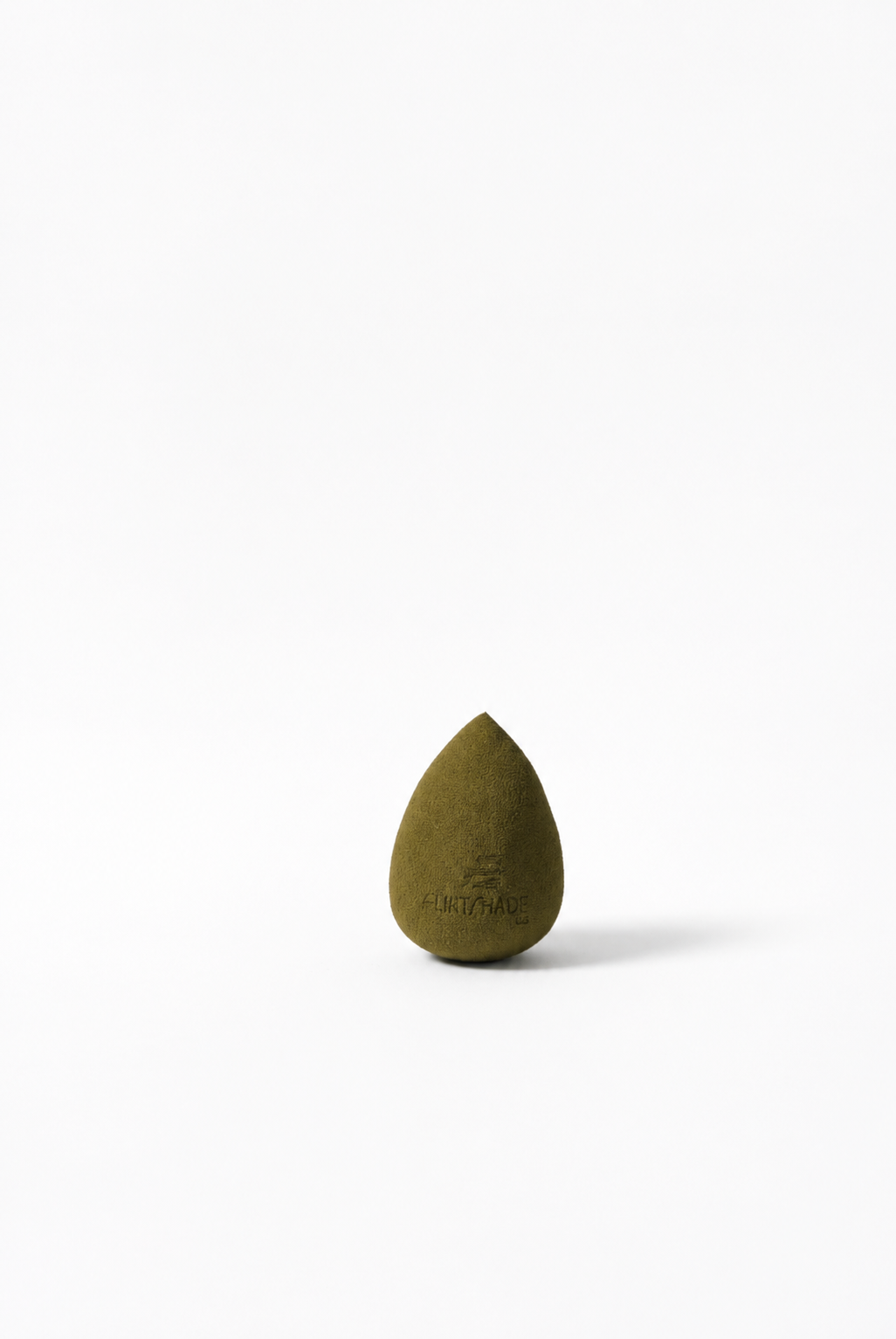Green teardrop-shaped beauty blender on a white background